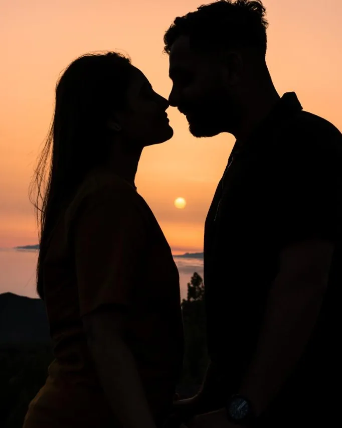 Sagoma di una coppia vicina al bacio, in controluce al tramonto